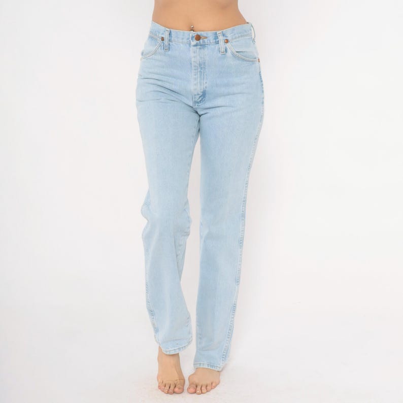Op de afbeelding: Lichtblauwe denim jeans met een klassieke rechte pijp. De jeans heeft een knoop- en ritssluiting, voor- en achterzakken en een lichte wassing. De jeans wordt getoond tegen een witte achtergrond.