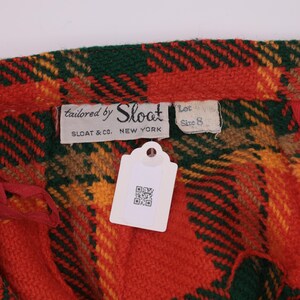 May include: Red, green, yellow, and brown plaid fabric with a white tag and a label that reads "tailored by Sloat, Sloat & Co., New York, Lot Size 8".