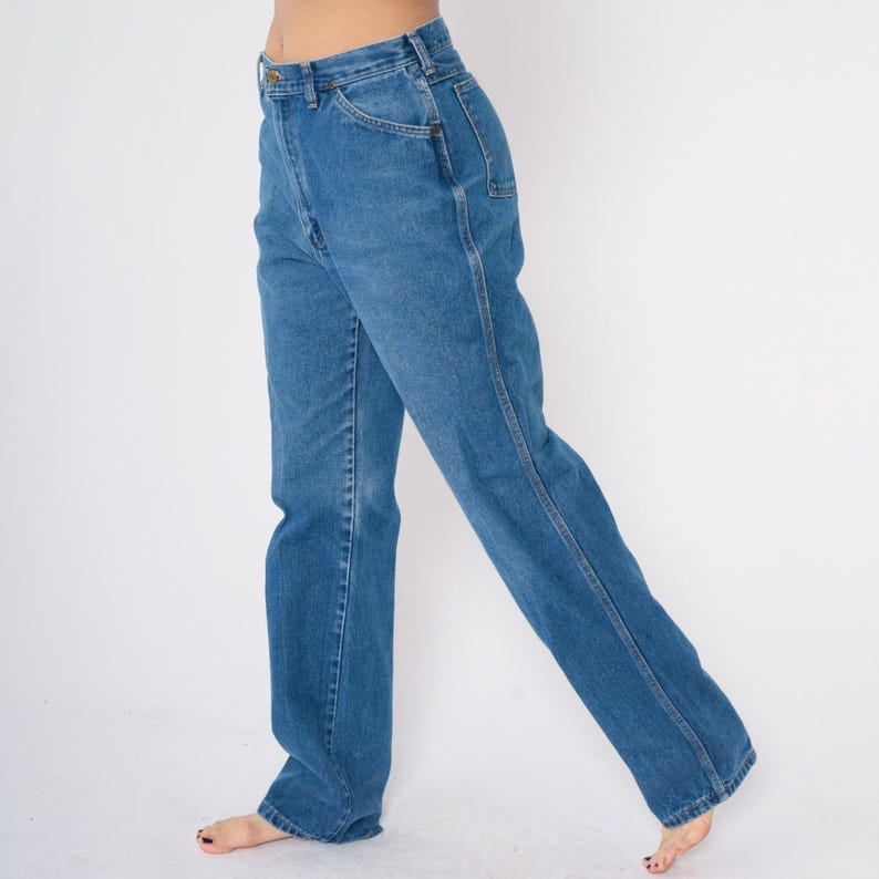 May include: A pair of blue denim jeans with a straight leg fit. The jeans have a high waist and are made of a soft, comfortable fabric.