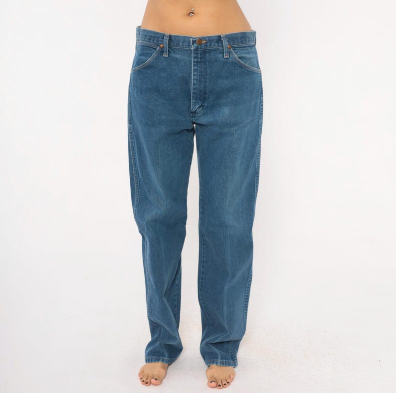 May include: Blue denim jeans with a classic straight-leg fit. The jeans have a button and zipper closure, with front and back pockets. The denim has a medium wash and a slightly faded appearance. The jeans are a timeless wardrobe staple.