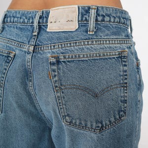May include: A pair of light blue denim jeans with a back pocket and a white tag that says "Made in the USA" on the back waistband.