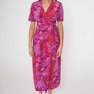 May include: A pink and red floral print wrap dress with short sleeves and a V-neckline.