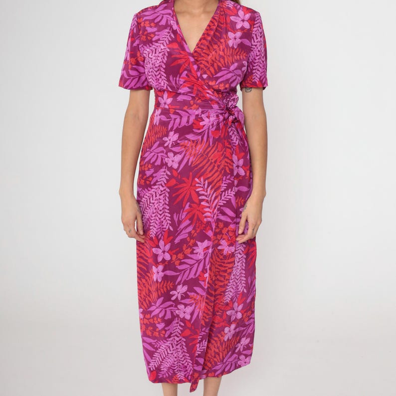May include: A pink and red floral print wrap dress with short sleeves and a V-neckline.