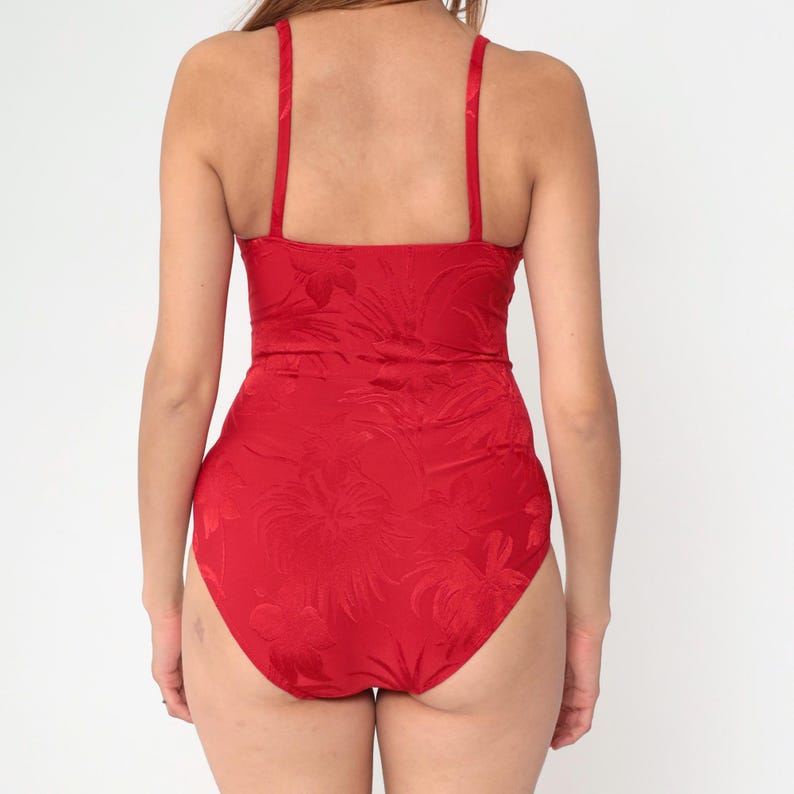 Peut inclure: Un maillot de bain une pi&egrave;ce rouge &agrave; motif floral. Le maillot de bain a un d&eacute;collet&eacute; arrondi et des bretelles fines.
