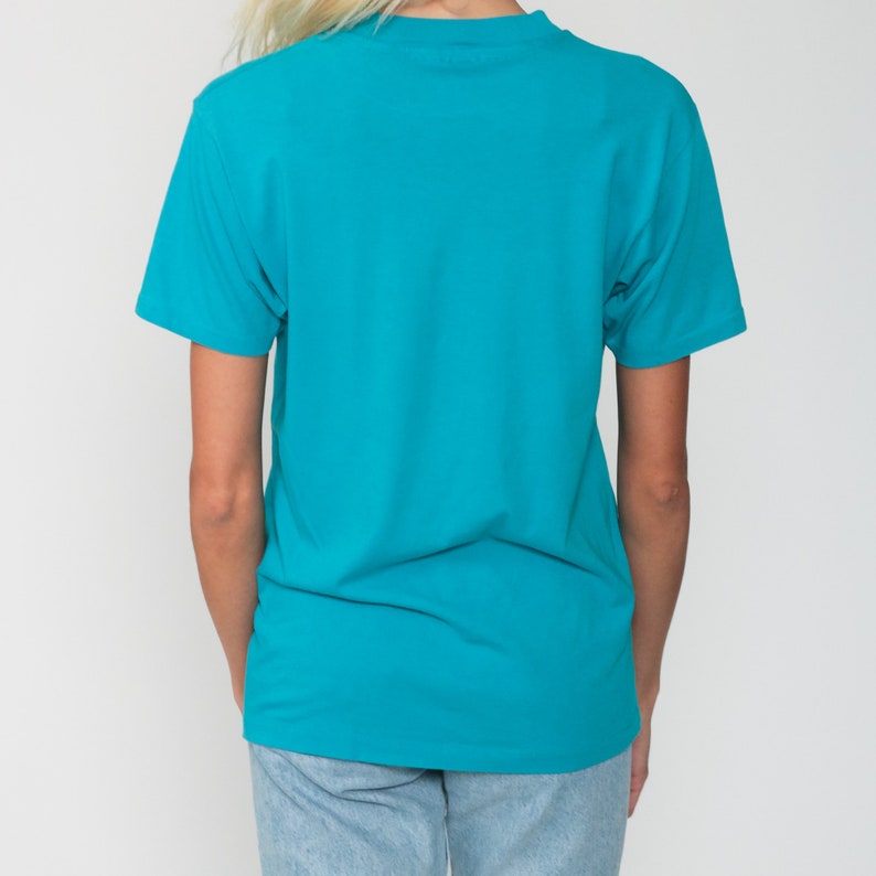 May include: A turquoise short-sleeved t-shirt with a crew neck.