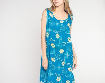 May include: A sleeveless blue dress with a yellow floral and fish print. The dress has a scoop neck and a loose fit.