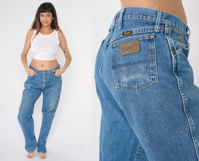 May include: A pair of blue denim jeans with a brown leather patch that says "Wrangler" on the back pocket.