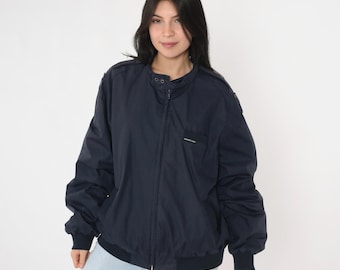 May include: A navy blue zip-up jacket with a stand-up collar and a small logo on the left chest.