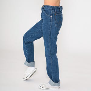 May include: A pair of blue denim jeans with a high waist and a straight leg. The jeans are cuffed at the bottom and have a classic look.
