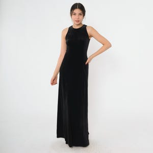 Może przedstawiać: Czarna, bezrękawowa sukienka maxi z weluru. Sukienka ma prosty, elegancki design i prosty kr&oacute;j.