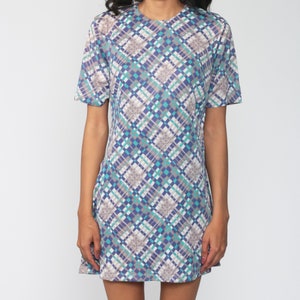 Puede incluir: Un vestido de manga corta con un patr&oacute;n geom&eacute;trico en tonos azules, grises y blancos.