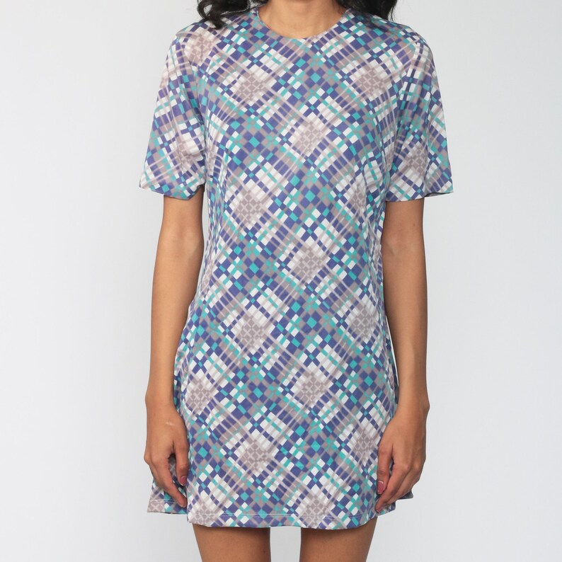 Puede incluir: Un vestido de manga corta con un patr&oacute;n geom&eacute;trico en tonos azules, grises y blancos.