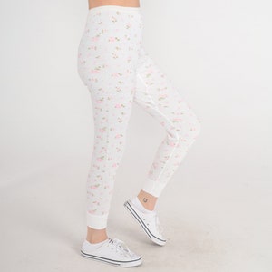 May include: White thermal leggings with a pink floral pattern. The leggings are made of a soft, stretchy fabric and have a comfortable fit.