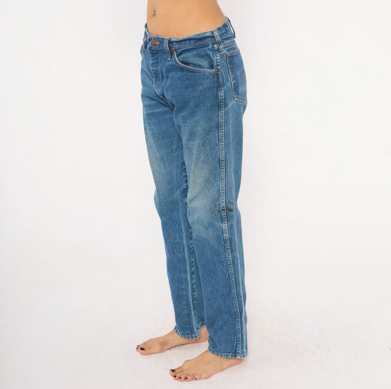 Pode incluir: Jeans azuis de ganga com um design cl&aacute;ssico de cinco bolsos. Os jeans t&ecirc;m um corte de perna reto e uma lavagem desbotada, dando-lhes um visual vintage. Os jeans s&atilde;o feitos de um tecido de ganga dur&aacute;vel.
