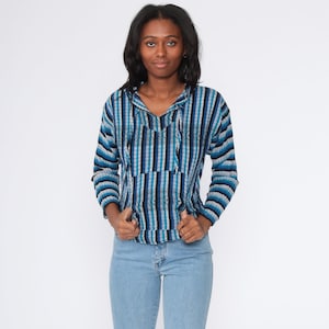 May include: A blue and white striped hooded pullover with a drawstring. The pullover has a pocket on the front and is made of a soft, comfortable fabric.