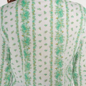 Puede incluir: Camisa blanca de manga larga con estampado floral verde y amarillo.
