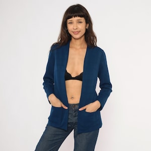 May include: A set of three ceramic mugs with a speckled, matte finish. The mugs are in shades of cream, light gray, and dark gray. Each mug has a simple, modern design and a rounded handle.