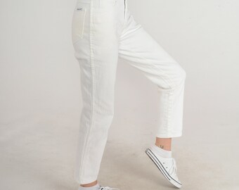 May include: White straight-leg jeans with a high waist and a relaxed fit. The jeans are made of a lightweight denim fabric and have a slightly cropped length.