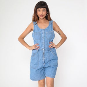 May include: A light blue denim overall short with a button closure and two front pockets.