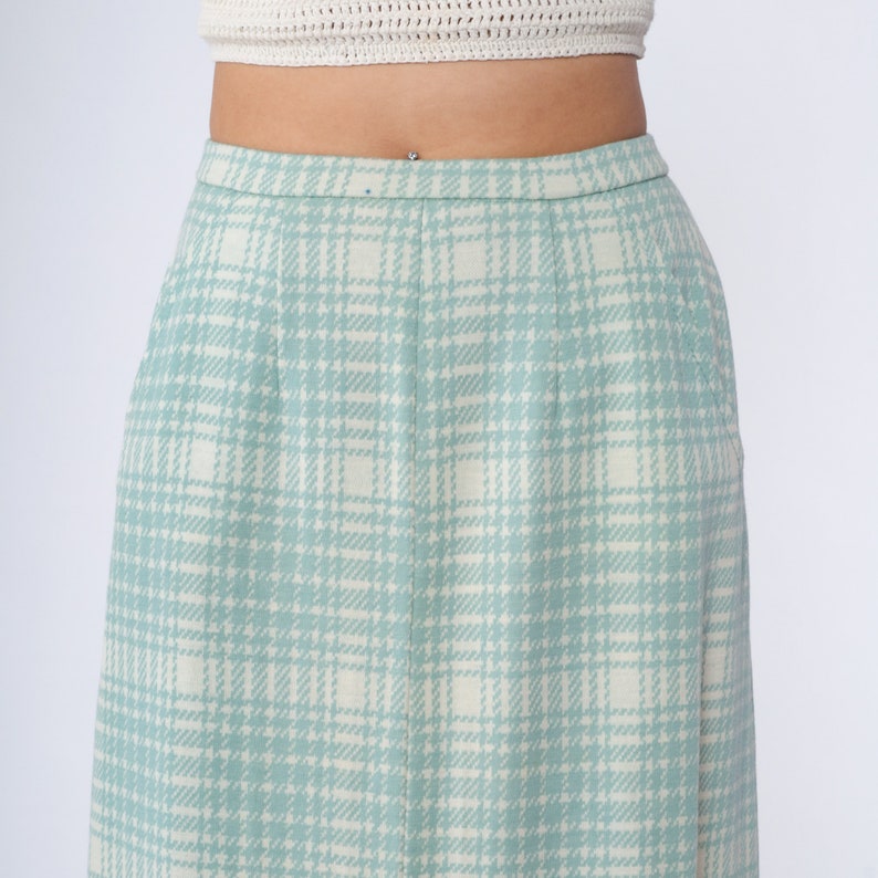 May include: A light blue plaid skirt with a white background. The skirt is knee-length and has a simple design.