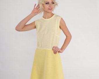 Puede incluir: Un vestido amarillo sin mangas con rayas blancas en la parte superior y una falda amarilla lisa. El vestido tiene un escote redondo.
