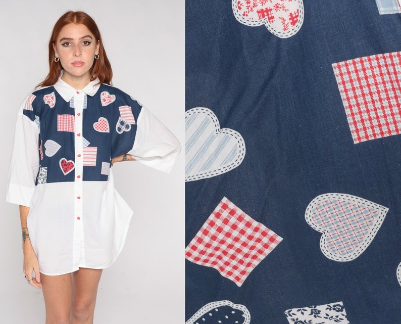 May include: White button-down shirt with a blue panel featuring a patchwork design of hearts, squares, and stripes in red, white, and blue.