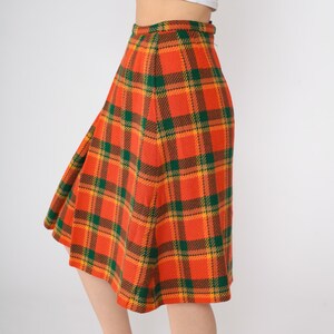 May include: A knee-length skirt with a plaid pattern in orange, green, and yellow.