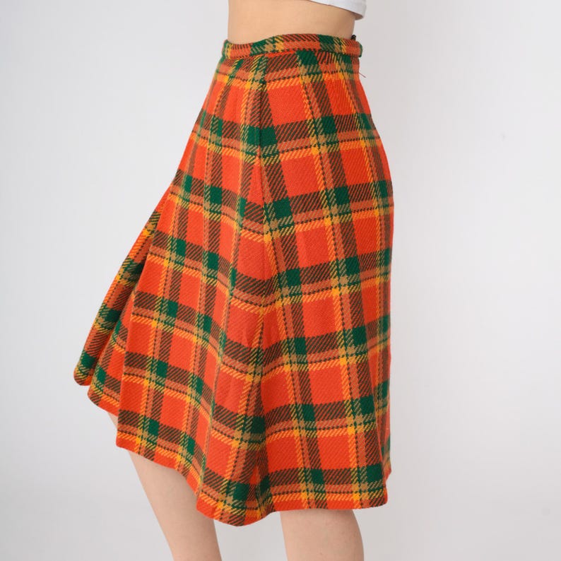 May include: A knee-length skirt with a plaid pattern in orange, green, and yellow.