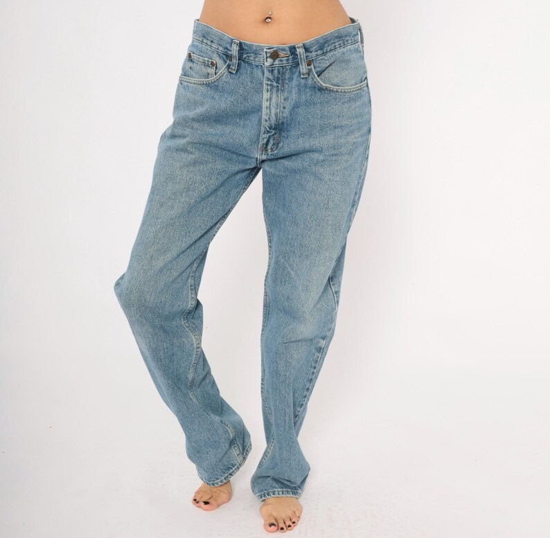 Peut inclure: Jean en denim bleu clair avec une conception classique &agrave; cinq poches. Le jean a une coupe droite et une fermeture &agrave; bouton et fermeture &eacute;clair. Le denim a un d&eacute;lavage d&eacute;color&eacute;, lui donnant un aspect vintage. Le jean est de style d&eacute;contract&eacute;.