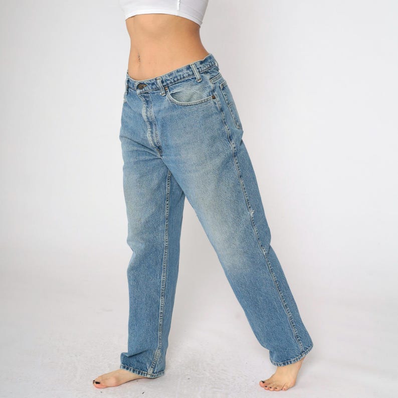 May include: A pair of light blue denim jeans with a relaxed fit. The jeans have a straight leg and a slightly faded wash.