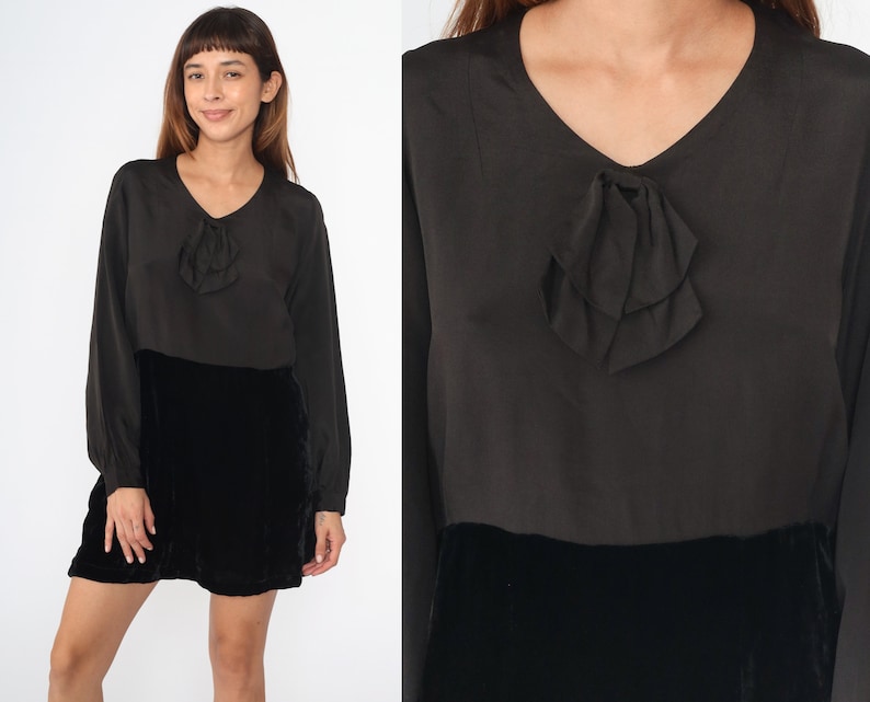 May include: A black velvet skirt with a black satin top featuring a bow detail. The top has long sleeves and a v-neck.