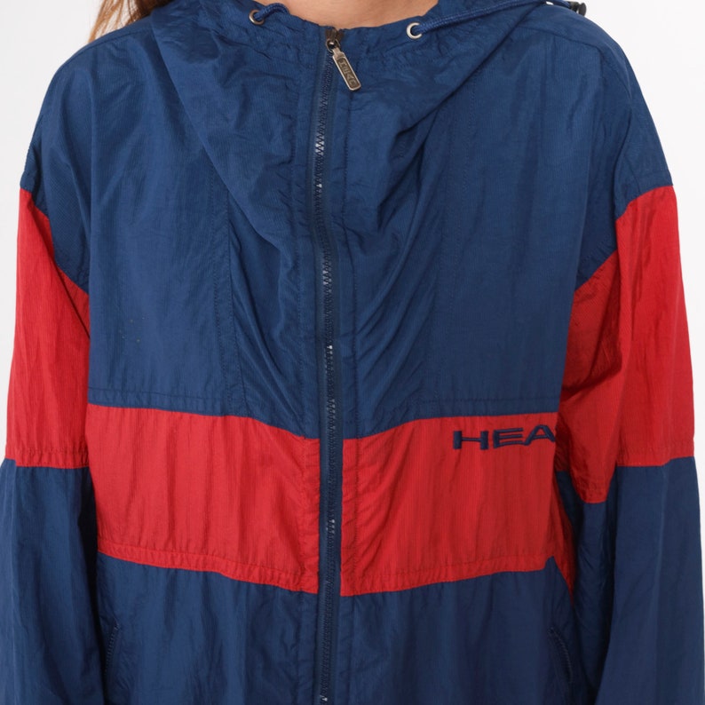 May include: A blue and red windbreaker jacket with a zipper closure and the word "HEATHER" embroidered on the front.