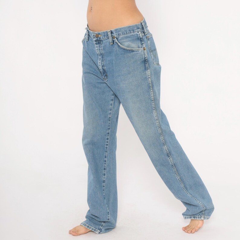 Peut inclure: Jean en denim bleu clair avec une conception classique &agrave; cinq poches. Le jean a une coupe droite et un d&eacute;lavage d&eacute;color&eacute;, lui donnant un aspect vintage. Le jean est fait d'un mat&eacute;riau en denim durable.
