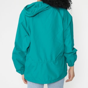 May include: Teal blue lightweight hooded jacket with a drawstring waist.