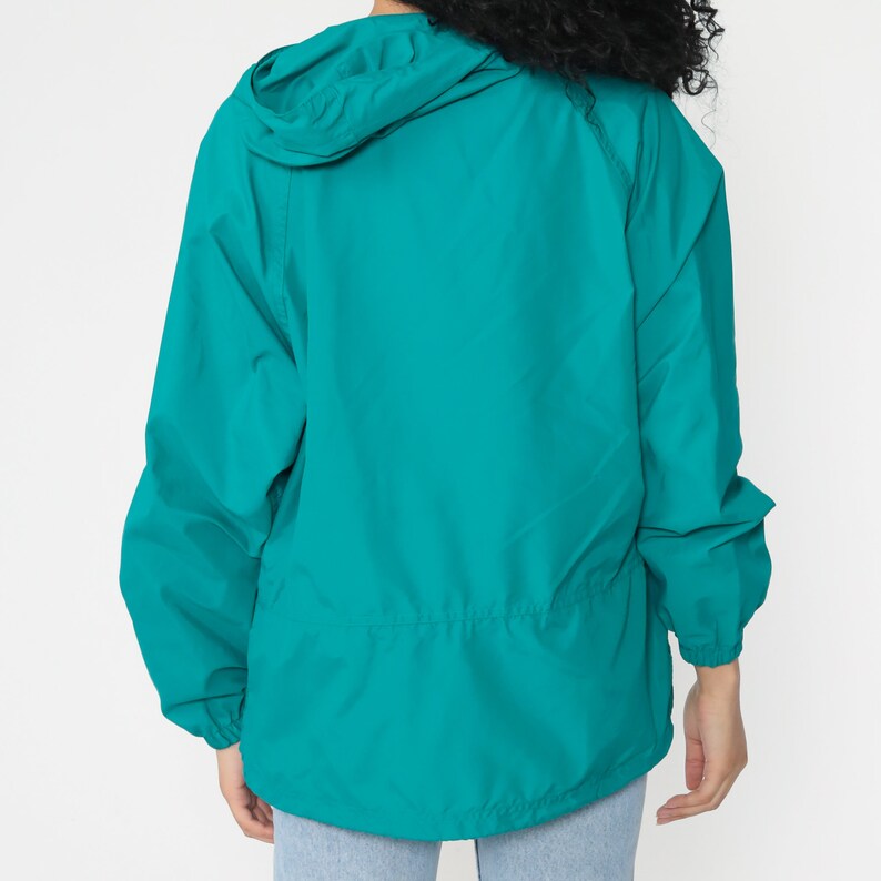 May include: Teal blue lightweight hooded jacket with a drawstring waist.