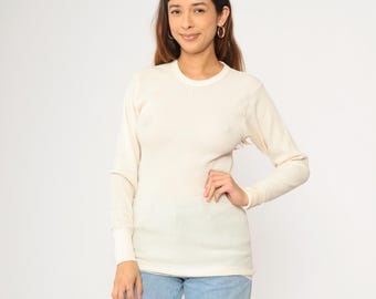 May include: A white long-sleeved thermal shirt with a crew neck.