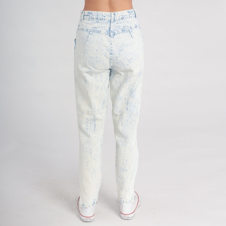 May include: Light blue acid wash jeans with a high waist and a straight leg fit.
