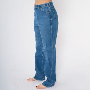 May include: A pair of blue denim jeans with a high waist and a straight leg fit.