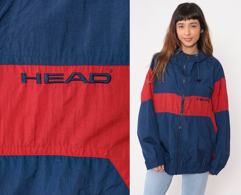 May include: A blue and red windbreaker jacket with the word "HEAD" in white lettering on the front. The jacket has a zipper closure and a hood.