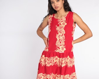 May include: A red sleeveless dress with a floral print. The dress has a gathered skirt and a scoop neckline.