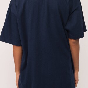 May include: Navy blue t-shirt with short sleeves. The shirt has a relaxed fit and a simple, classic design. The fabric appears to be a soft, comfortable material, suitable for casual wear. The back of the shirt is visible.