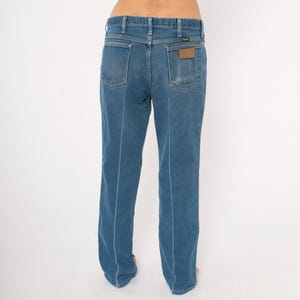 Peut inclure: Jean bleu en denim avec une conception classique &agrave; cinq poches. Le jean a une coupe droite et un patch en cuir marron au dos. Les coutures sont bleu clair, cr&eacute;ant un contraste avec le denim.