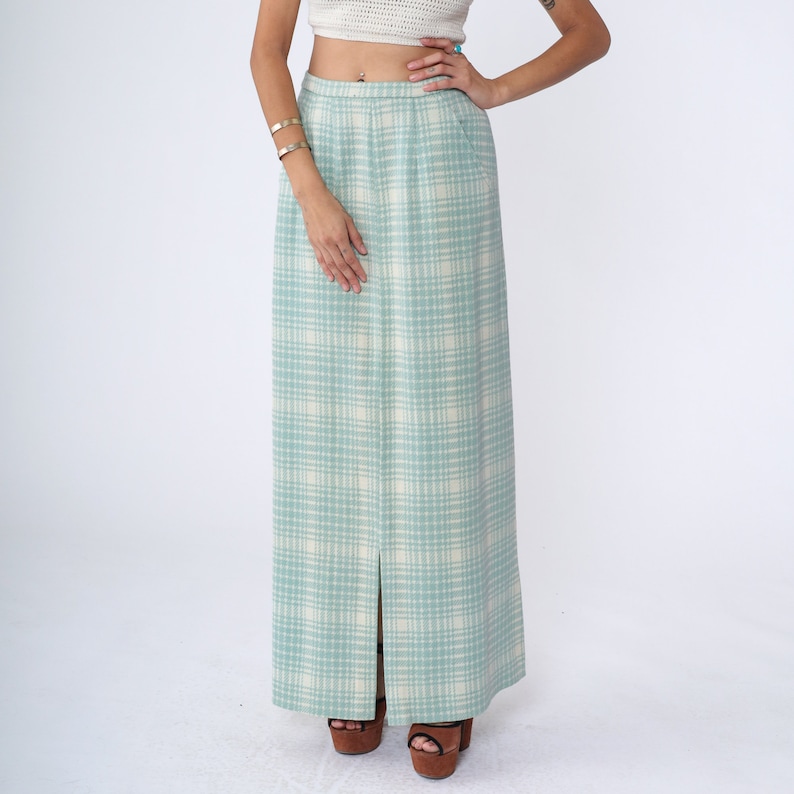 May include: A long, light blue skirt with a white plaid pattern. The skirt has a front slit and a high waist.