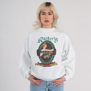 May include: White sweatshirt with a green and gold logo that says "Rucker's Altmo dische Biergarten" and features a woman holding beer steins.