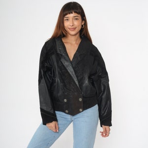 May include: A black leather jacket with a suede collar and double-breasted closure. The jacket has a textured pattern and a slightly cropped fit.