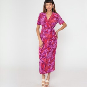 May include: A pink and red floral print wrap dress with short sleeves and a tie at the waist.