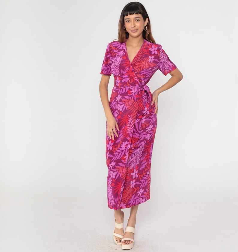 May include: A pink and red floral print wrap dress with short sleeves and a tie at the waist.
