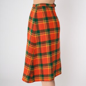 May include: A long orange, green, and yellow plaid skirt.
