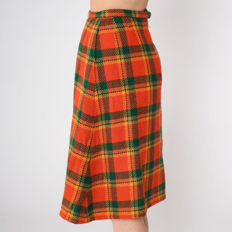 May include: A long orange, green, and yellow plaid skirt.
