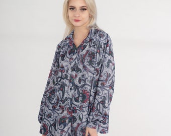 May include: A long-sleeved button-down shirt with a paisley print in shades of blue, red, and white.